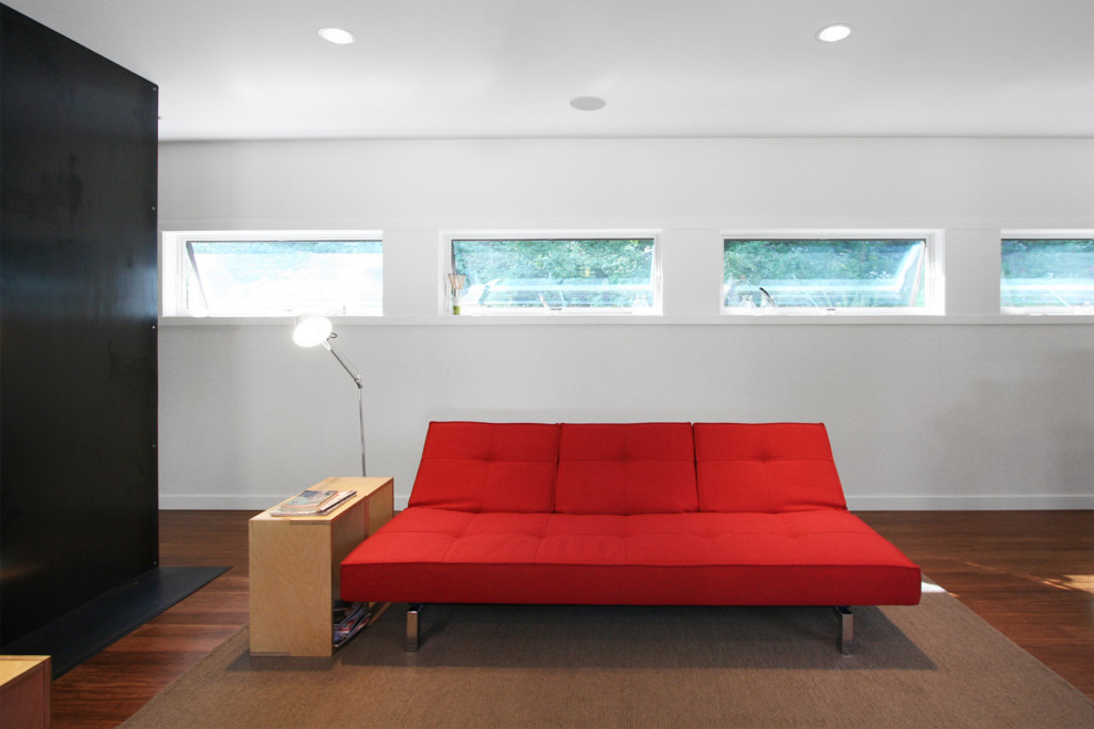 Mittelgroßes, Offenes Modernes Wohnzimmer mit weißer Wandfarbe, braunem Holzboden, Kaminofen und Kaminumrandung aus Metall in New York