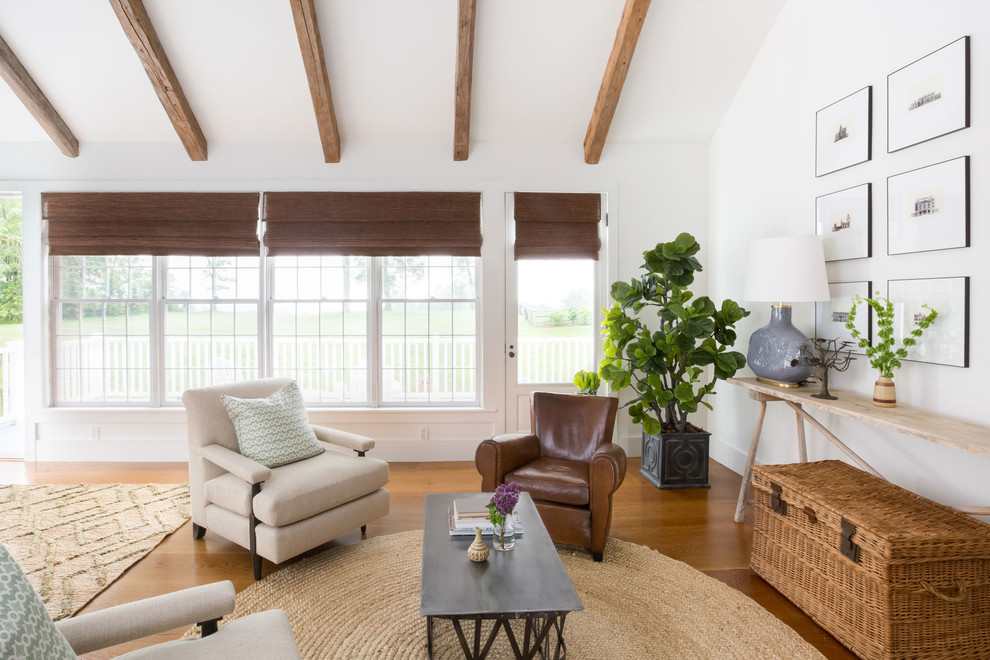 Modelo de salón para visitas abierto campestre sin televisor con paredes blancas, suelo de madera en tonos medios y suelo marrón