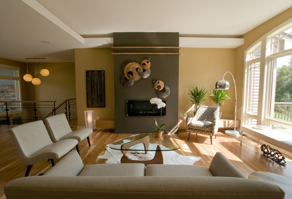 На фото: гостиная комната в современном стиле с желтыми стенами и горизонтальным камином с