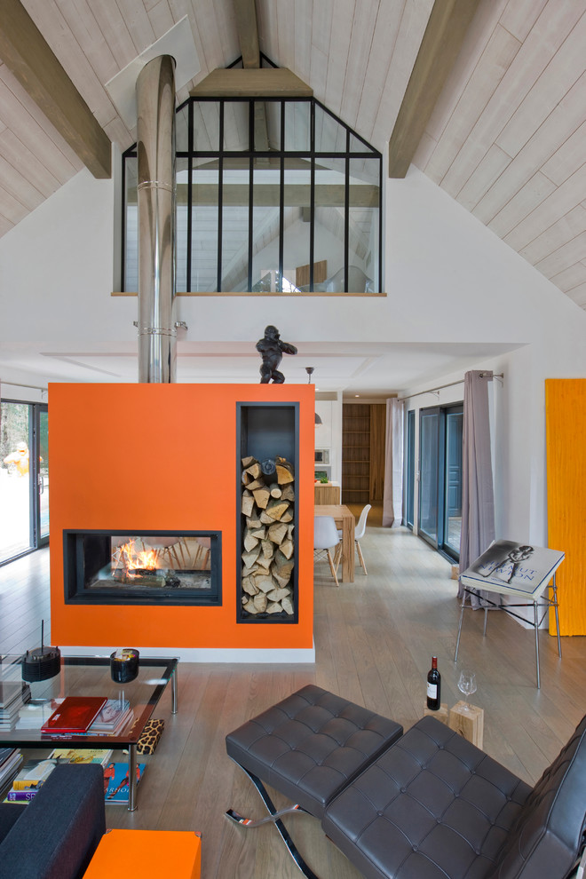 Свежая идея для дизайна: открытая гостиная комната среднего размера в современном стиле с оранжевыми стенами, паркетным полом среднего тона и двусторонним камином без телевизора - отличное фото интерьера