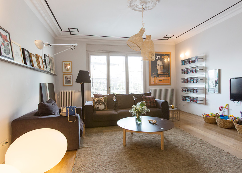 Ejemplo de salón para visitas cerrado contemporáneo grande sin chimenea con paredes blancas, suelo de madera clara y televisor colgado en la pared