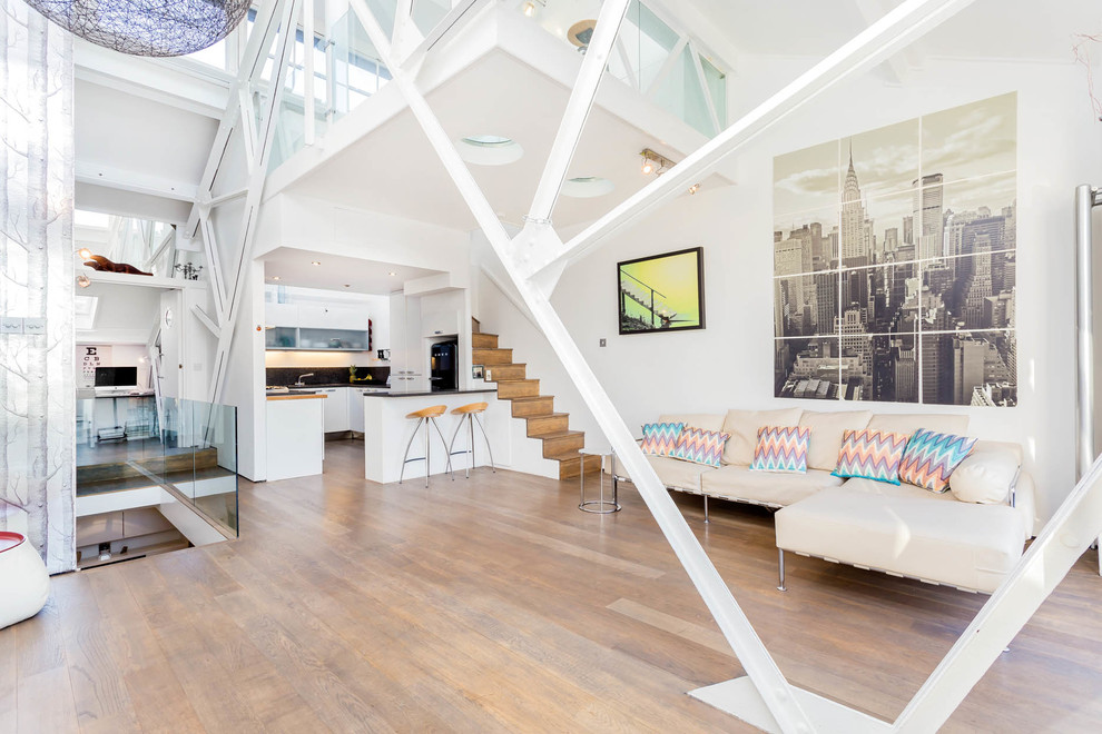 Foto di un soggiorno minimal stile loft con pareti bianche, pavimento in legno massello medio e pavimento marrone