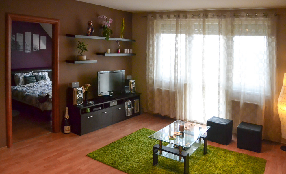 На фото: гостиная комната в современном стиле с бежевыми стенами и отдельно стоящим телевизором