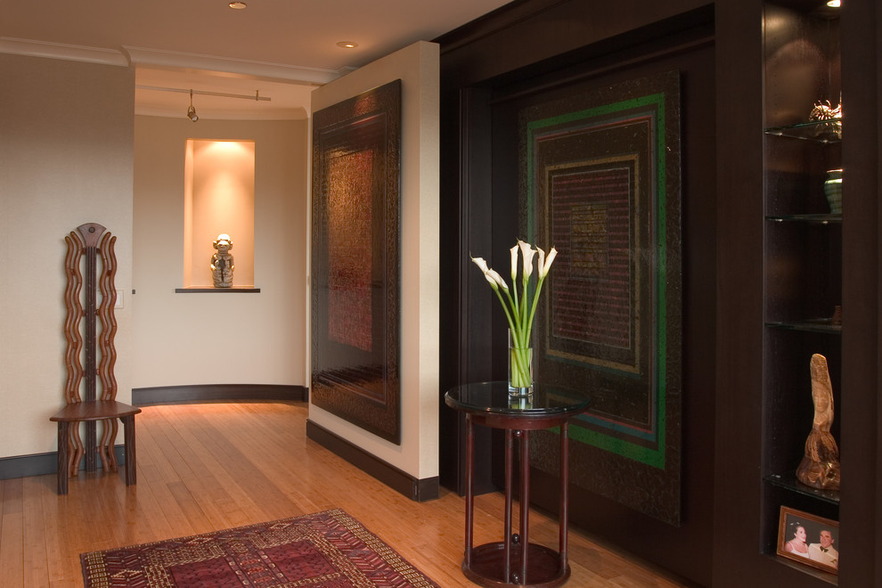 Foto di un soggiorno contemporaneo con libreria, pareti beige e pavimento in bambù