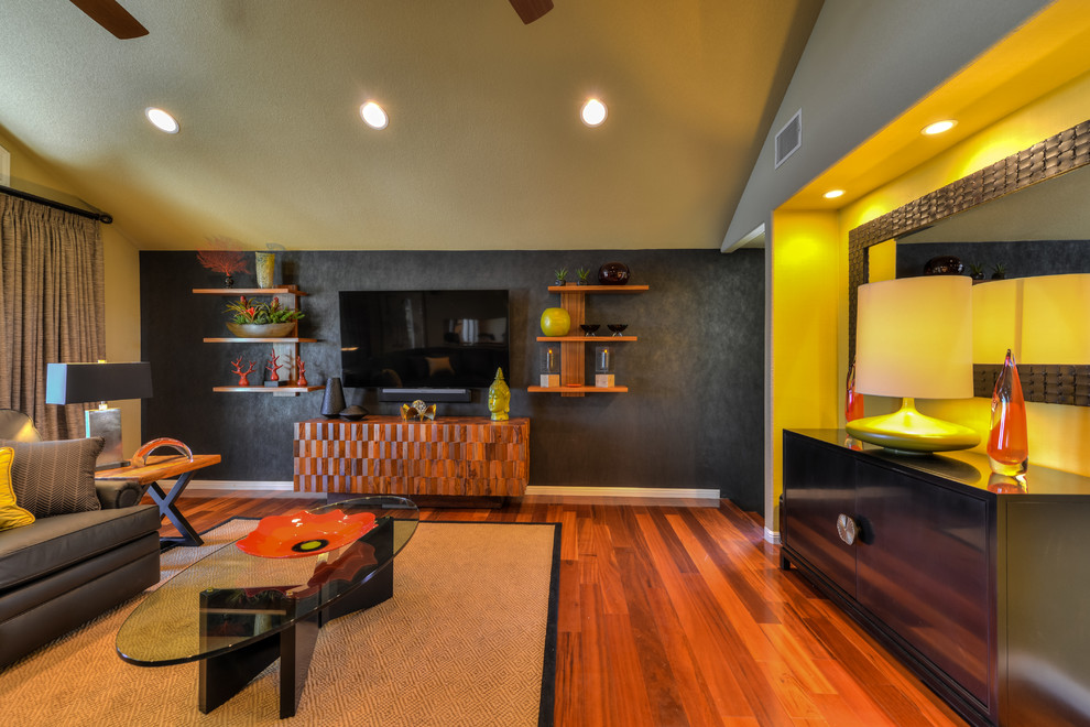 Foto di un soggiorno design di medie dimensioni e aperto con pareti grigie, pavimento in legno massello medio e TV a parete