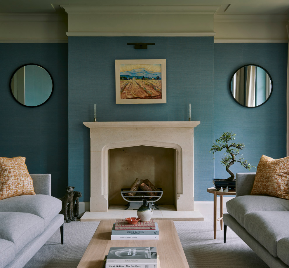На фото: большая парадная гостиная комната в стиле неоклассика (современная классика) с синими стенами, ковровым покрытием, стандартным камином и фасадом камина из камня без телевизора