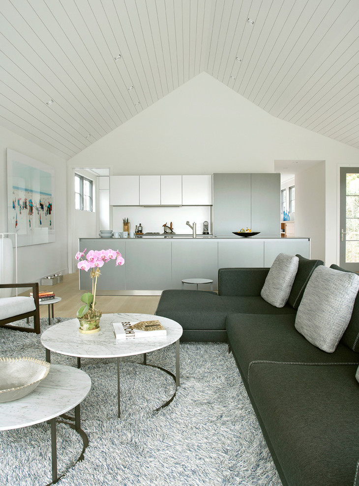 Esempio di un soggiorno contemporaneo aperto con pareti bianche e pavimento beige