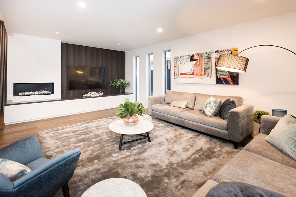 Großes, Offenes Modernes Wohnzimmer mit schwarzer Wandfarbe, braunem Holzboden, Tunnelkamin, verputzter Kaminumrandung, TV-Wand und braunem Boden in Melbourne