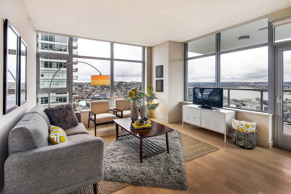 Kleines, Repräsentatives Modernes Wohnzimmer mit beiger Wandfarbe, hellem Holzboden und freistehendem TV in Seattle