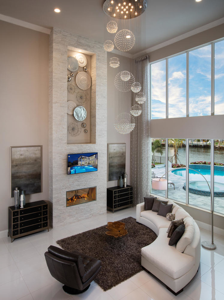 Großes, Offenes Modernes Wohnzimmer mit grauer Wandfarbe, Porzellan-Bodenfliesen, Tunnelkamin, Kaminumrandung aus Stein, Multimediawand und weißem Boden in Miami