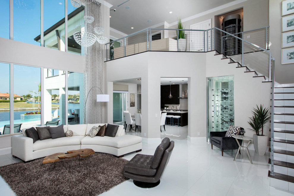 Exemple d'un grand salon tendance ouvert avec un sol en carrelage de porcelaine, un manteau de cheminée en pierre, un sol blanc, un mur gris, une cheminée double-face et un téléviseur encastré.