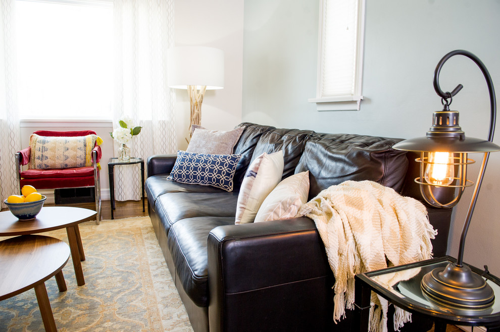 Immagine di un soggiorno design di medie dimensioni e aperto con pareti blu, pavimento in legno massello medio, nessun camino e TV a parete