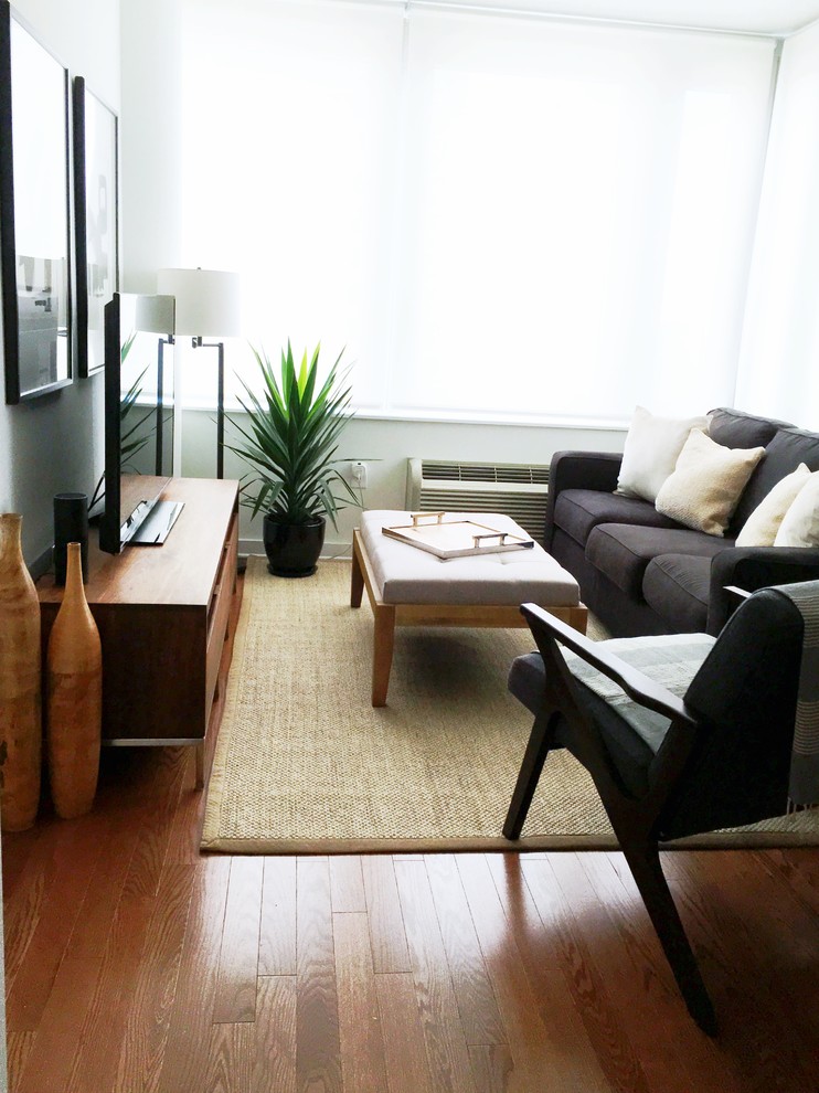 Ejemplo de salón para visitas abierto moderno pequeño sin chimenea y televisor con paredes blancas, suelo de madera en tonos medios y suelo marrón
