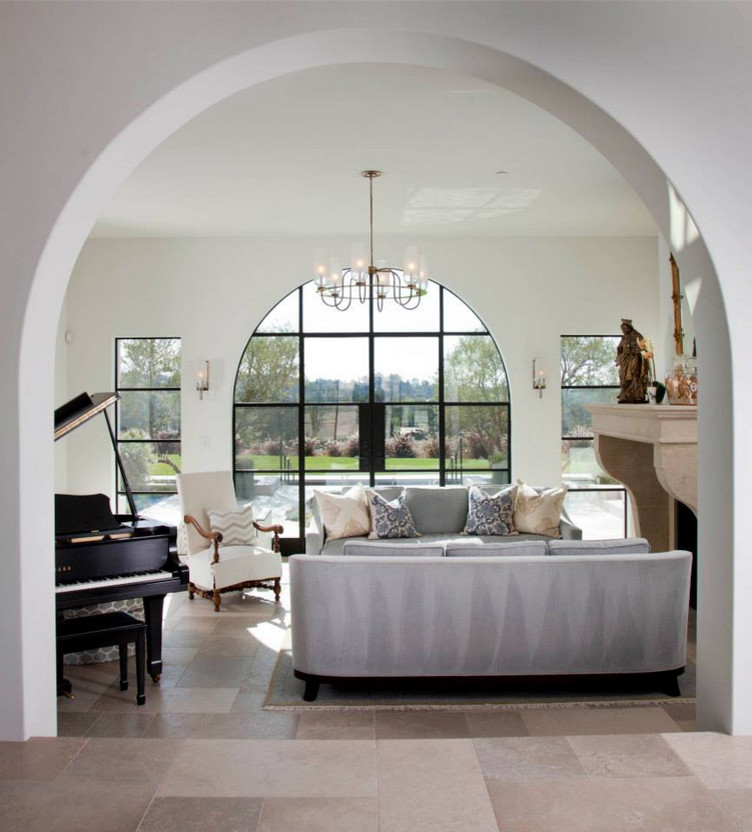 На фото: открытая гостиная комната среднего размера в стиле неоклассика (современная классика) с музыкальной комнатой, белыми стенами, стандартным камином, полом из известняка, фасадом камина из камня и бежевым полом без телевизора