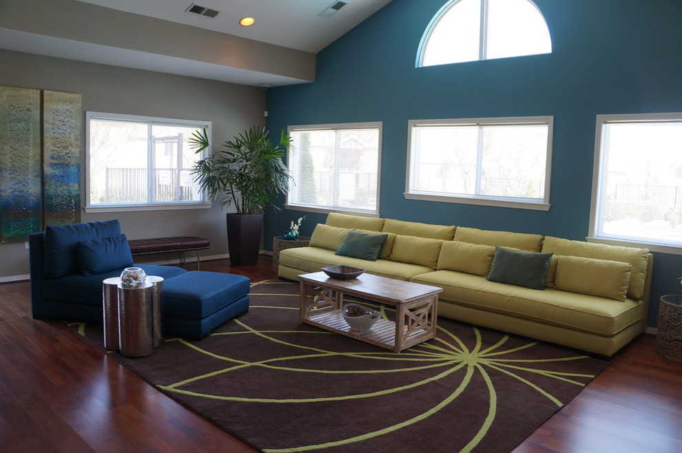 Inspiration pour un grand salon design ouvert avec un mur bleu, un sol en bois brun et aucune cheminée.