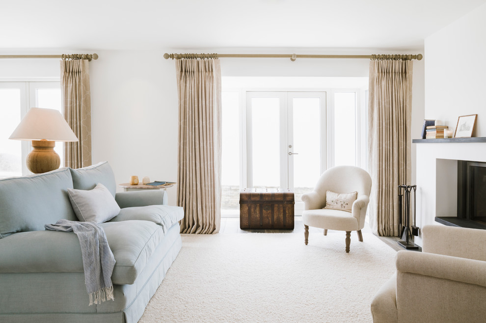 Источник вдохновения для домашнего уюта: большая гостиная комната в морском стиле с белыми стенами, ковровым покрытием, стандартным камином и синим диваном без телевизора