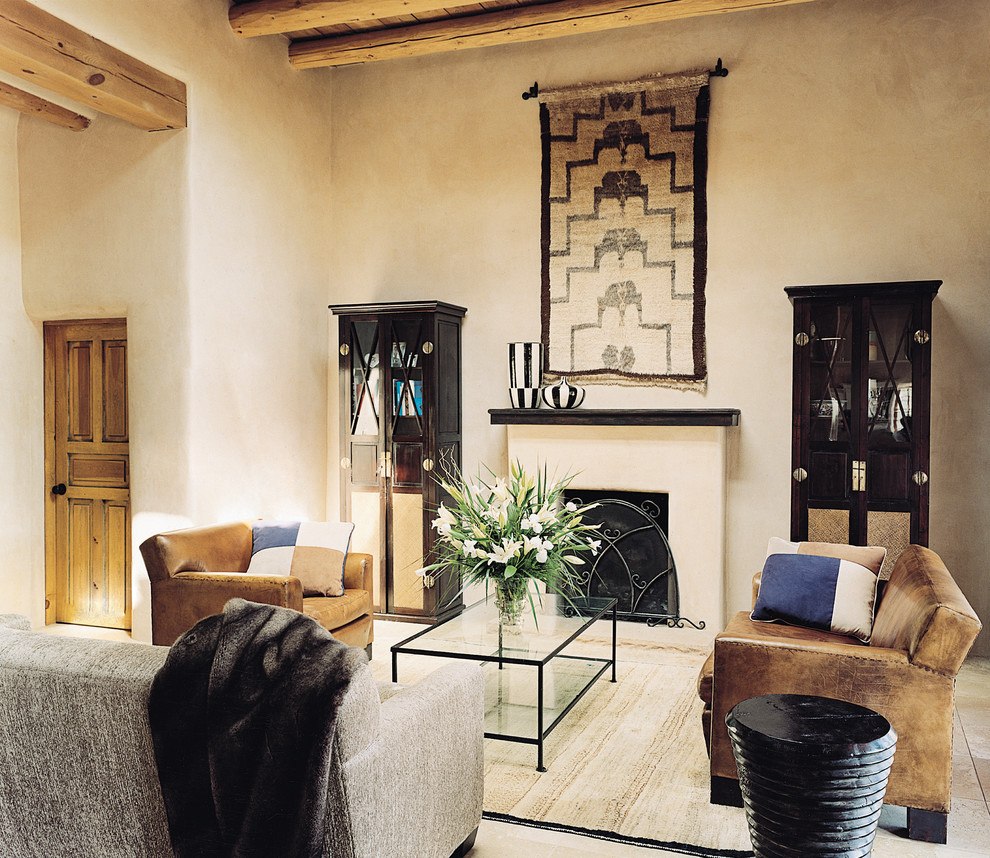 Inspiration pour un grand salon sud-ouest américain avec une salle de réception, un mur beige, un sol en calcaire, une cheminée standard et un manteau de cheminée en bois.