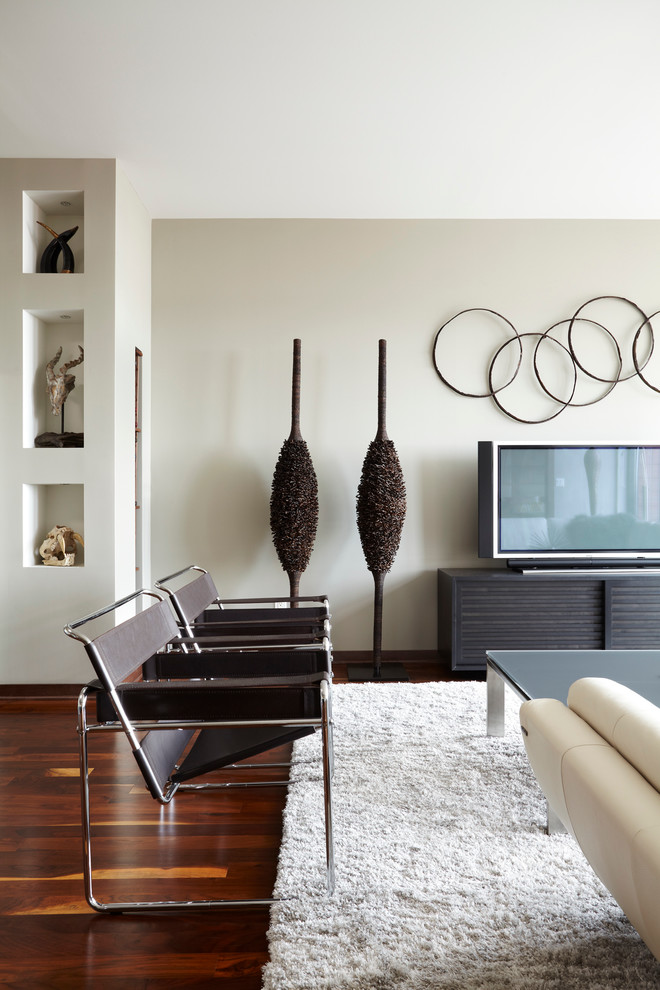 Пример оригинального дизайна: открытая гостиная комната среднего размера в современном стиле с серыми стенами, темным паркетным полом и отдельно стоящим телевизором