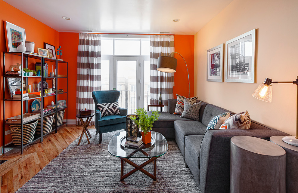 Inspiration for a small contemporary open concept light wood floor living room remodel in Chicago with orange walls and no fireplace