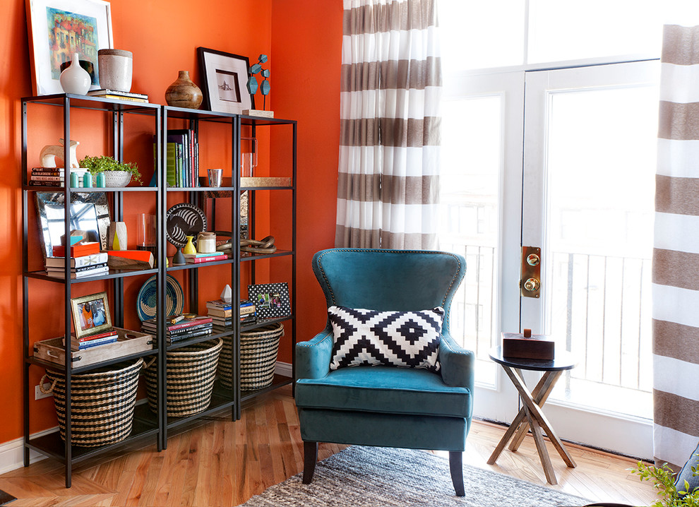 Immagine di un piccolo soggiorno design aperto con pareti arancioni, parquet chiaro e nessun camino