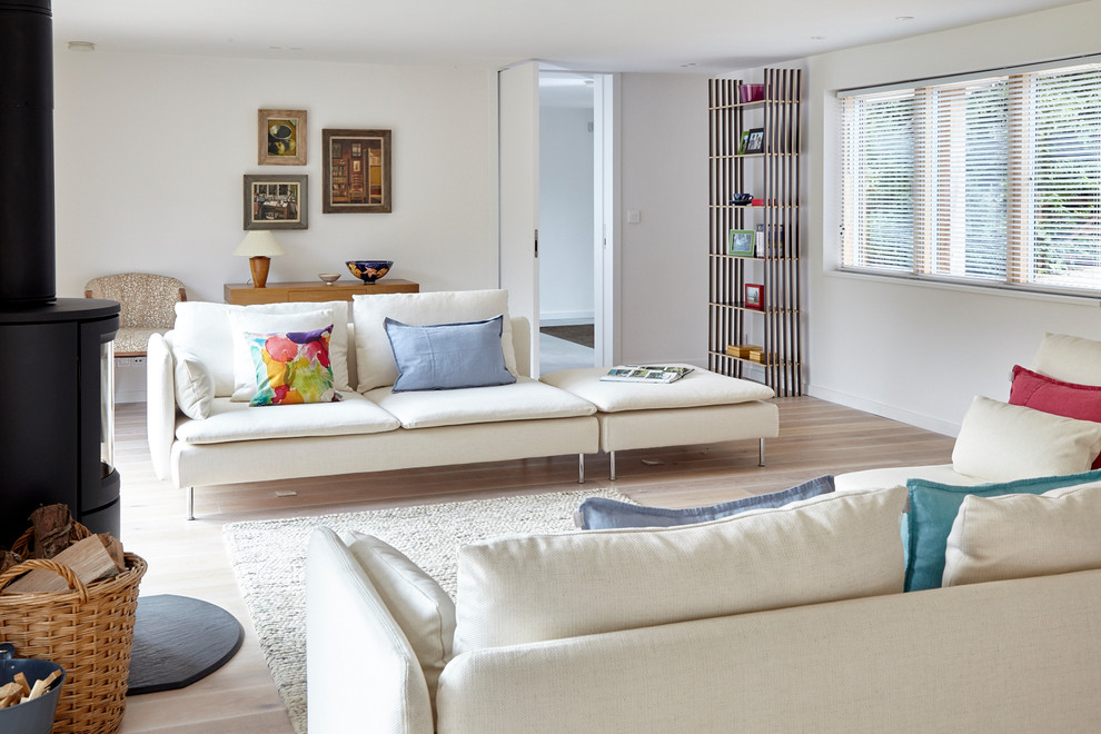 Immagine di un grande soggiorno design con parquet chiaro e stufa a legna