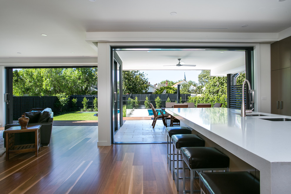 Cette image montre un grand salon design ouvert avec un sol en bois brun et une cheminée standard.