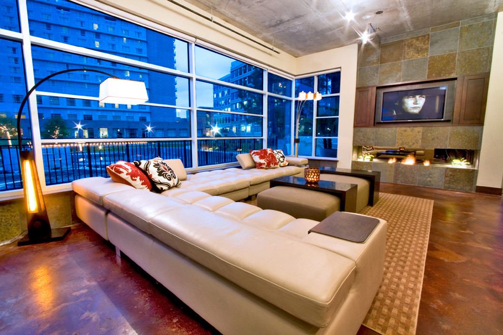 Großes Modernes Wohnzimmer im Loft-Stil mit beiger Wandfarbe, Gaskamin, Kaminumrandung aus Stein und verstecktem TV in Houston