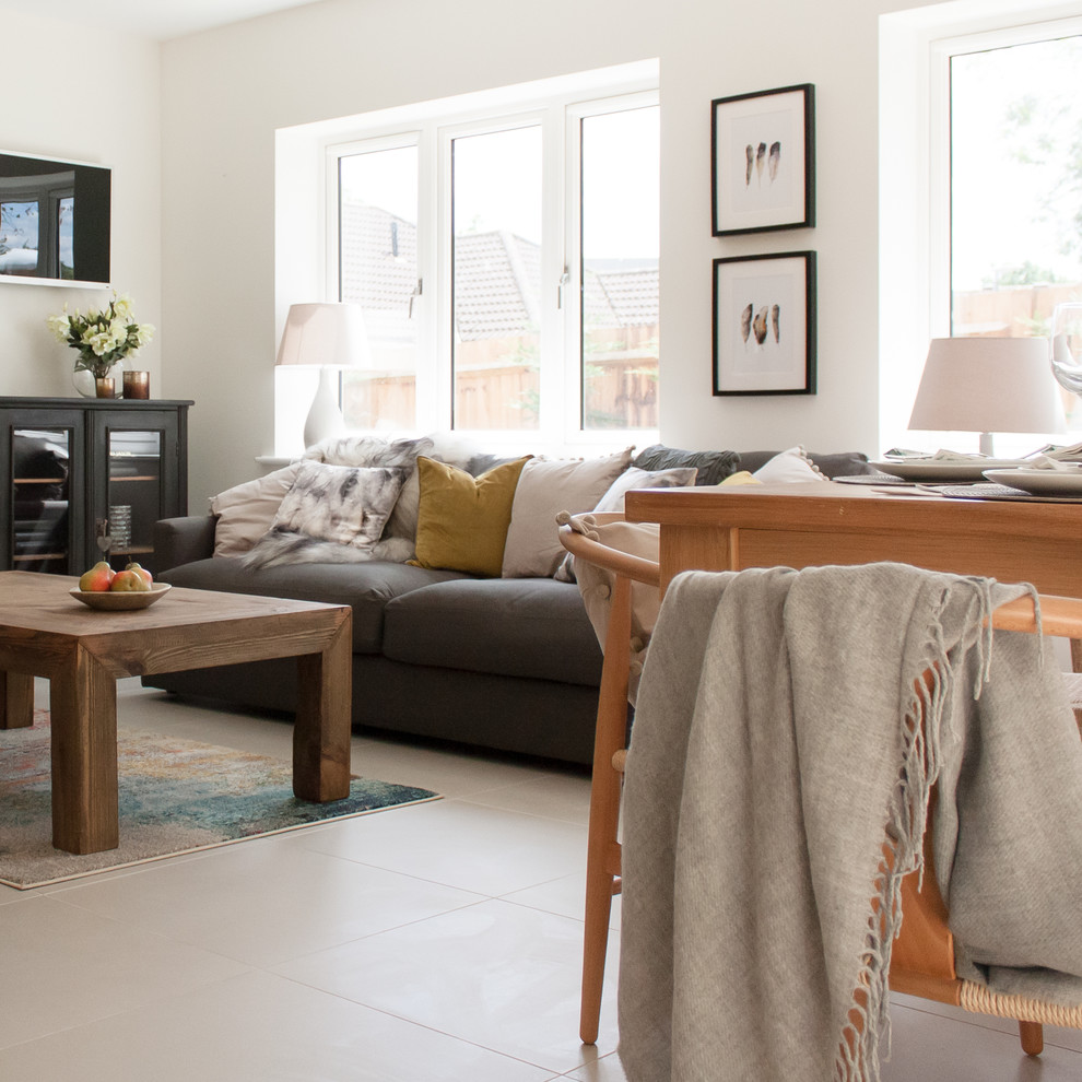 Design ideas for a medium sized modern open plan living room in Hertfordshire with white walls, porcelain flooring, a wood burning stove, a plastered fireplace surround and beige floors.