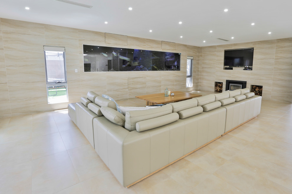 Large contemporary open plan living room in Sydney with porcelain flooring, a wood burning stove, a tiled fireplace surround, a wall mounted tv, beige walls and beige floors.