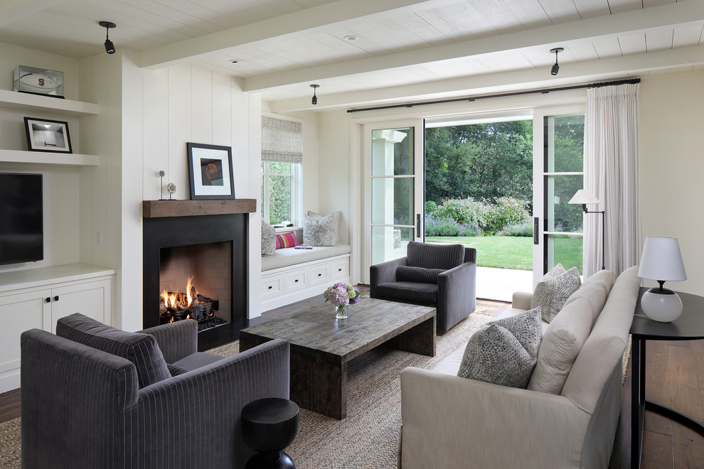 Exemple d'un salon nature avec un mur blanc, parquet foncé, une cheminée standard et un sol marron.