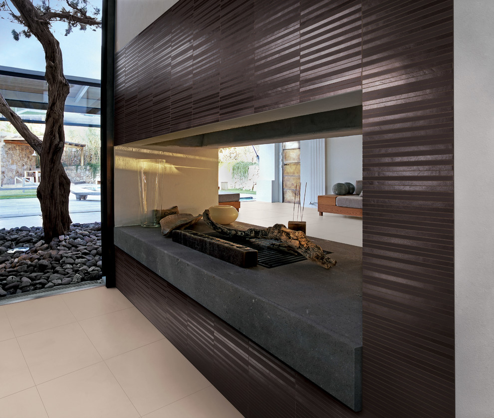 Cette image montre un très grand salon design ouvert avec un mur marron, une cheminée double-face et un manteau de cheminée en carrelage.