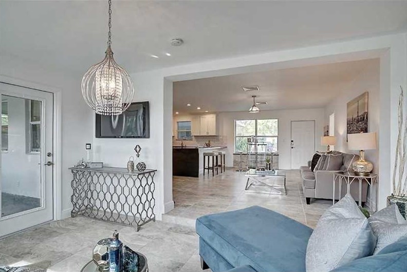 This is an example of a medium sized contemporary formal open plan living room in Miami with white walls, ceramic flooring, no fireplace, a wall mounted tv and grey floors.
