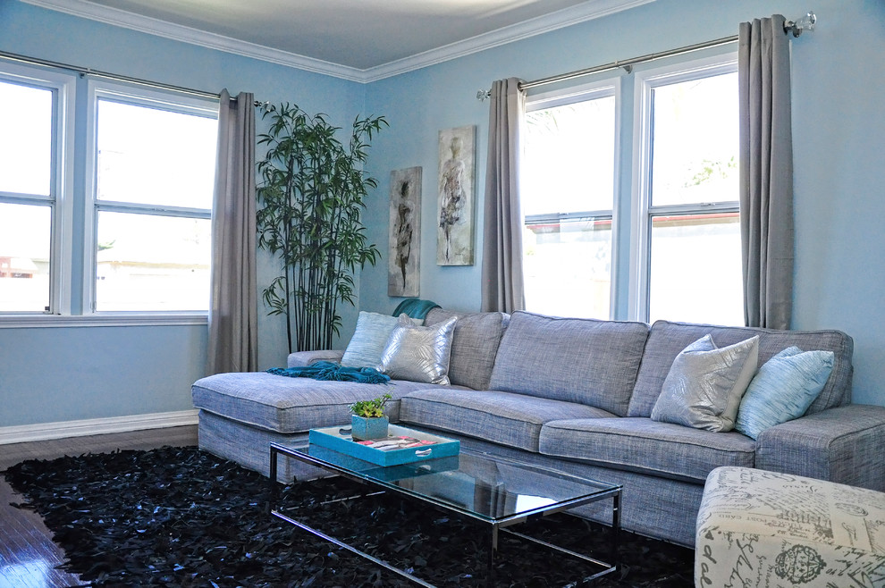 Kleines, Offenes Modernes Wohnzimmer ohne Kamin mit blauer Wandfarbe, braunem Holzboden und TV-Wand in Los Angeles