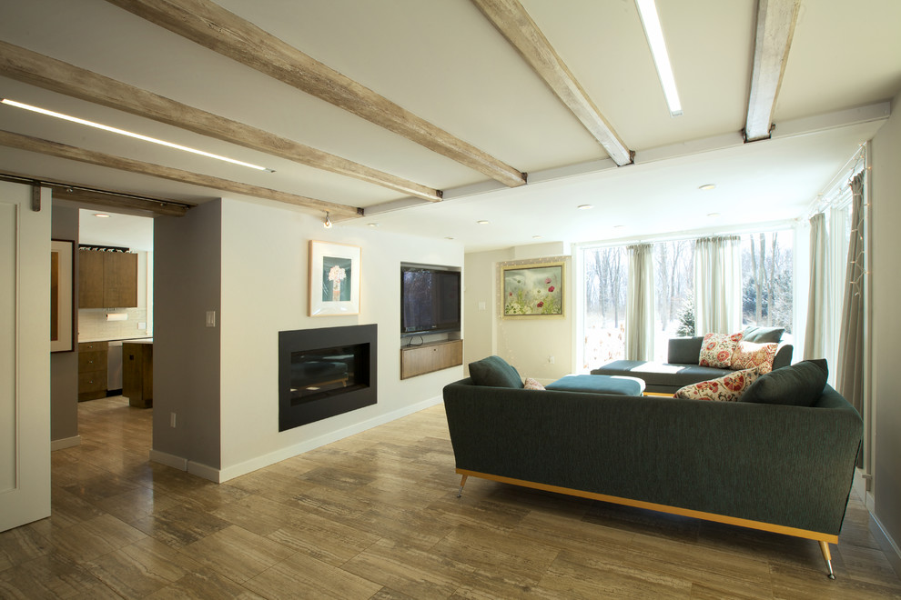 Diseño de salón abierto contemporáneo de tamaño medio con paredes grises, suelo de madera clara, todas las chimeneas y televisor colgado en la pared