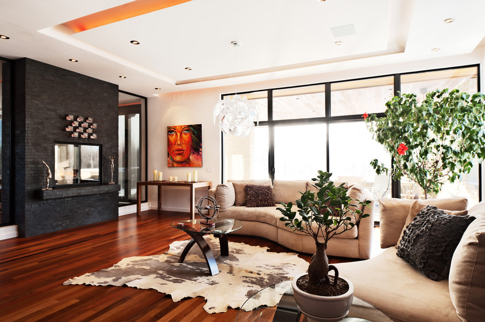 Photo of a large contemporary living room in Montreal with a two-sided fireplace.