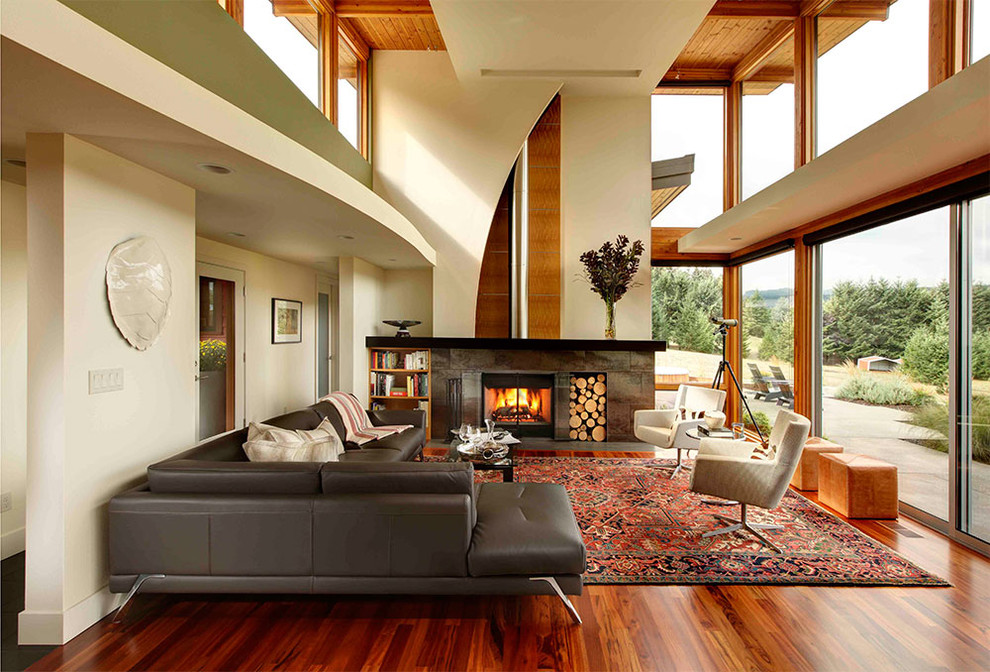 Esempio di un soggiorno minimalista aperto con libreria, pareti beige, pavimento in legno massello medio, stufa a legna, pavimento arancione e tappeto