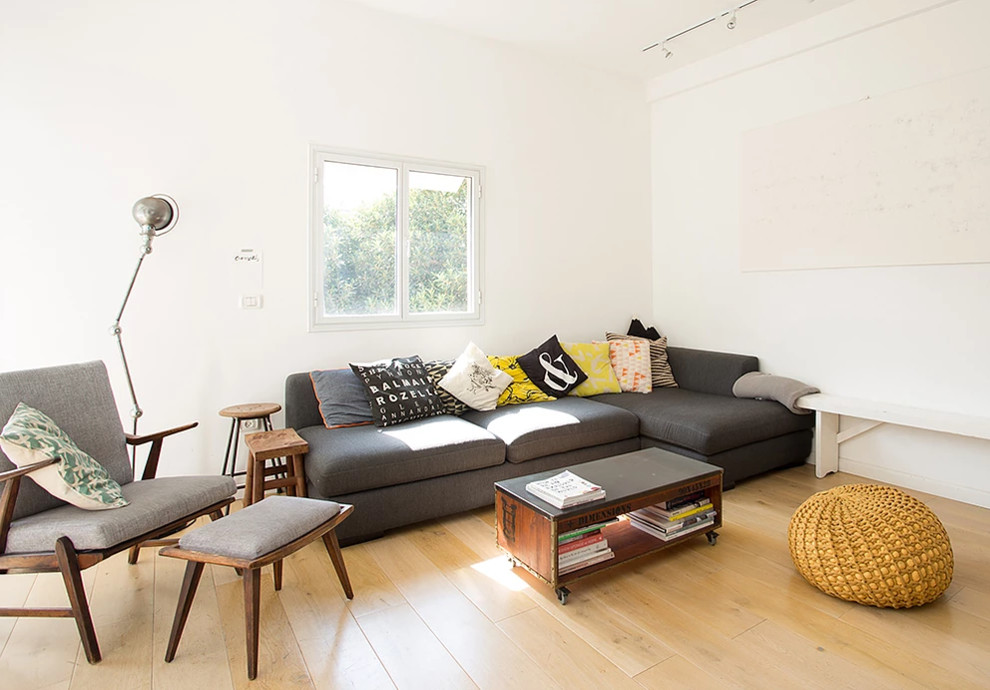 Immagine di un soggiorno minimalista di medie dimensioni e chiuso con sala formale, pareti bianche, parquet chiaro, nessun camino e pavimento beige