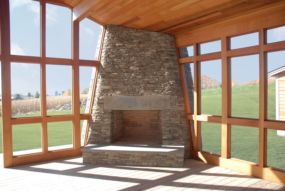 Modelo de salón rústico con chimenea de esquina y marco de chimenea de piedra