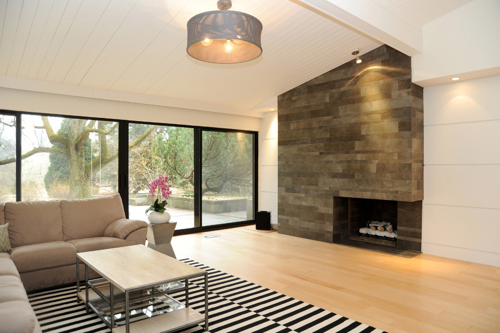 На фото: большая открытая гостиная комната в современном стиле с белыми стенами, светлым паркетным полом, стандартным камином и фасадом камина из камня