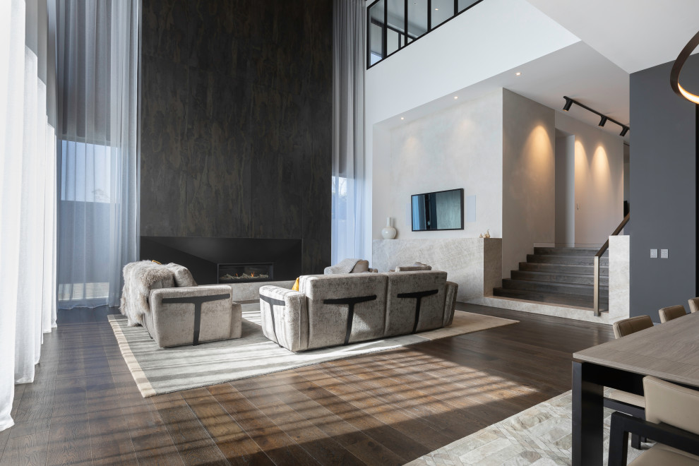 Offenes Modernes Wohnzimmer mit braunem Holzboden, Kamin, gefliester Kaminumrandung und braunem Boden in Melbourne
