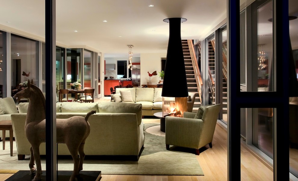 Источник вдохновения для домашнего уюта: открытая, парадная гостиная комната среднего размера в современном стиле с светлым паркетным полом, бежевыми стенами, подвесным камином и фасадом камина из металла