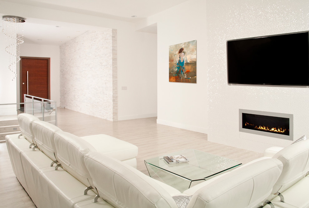 Modelo de salón contemporáneo extra grande con paredes blancas, suelo de linóleo, marco de chimenea de baldosas y/o azulejos y televisor colgado en la pared