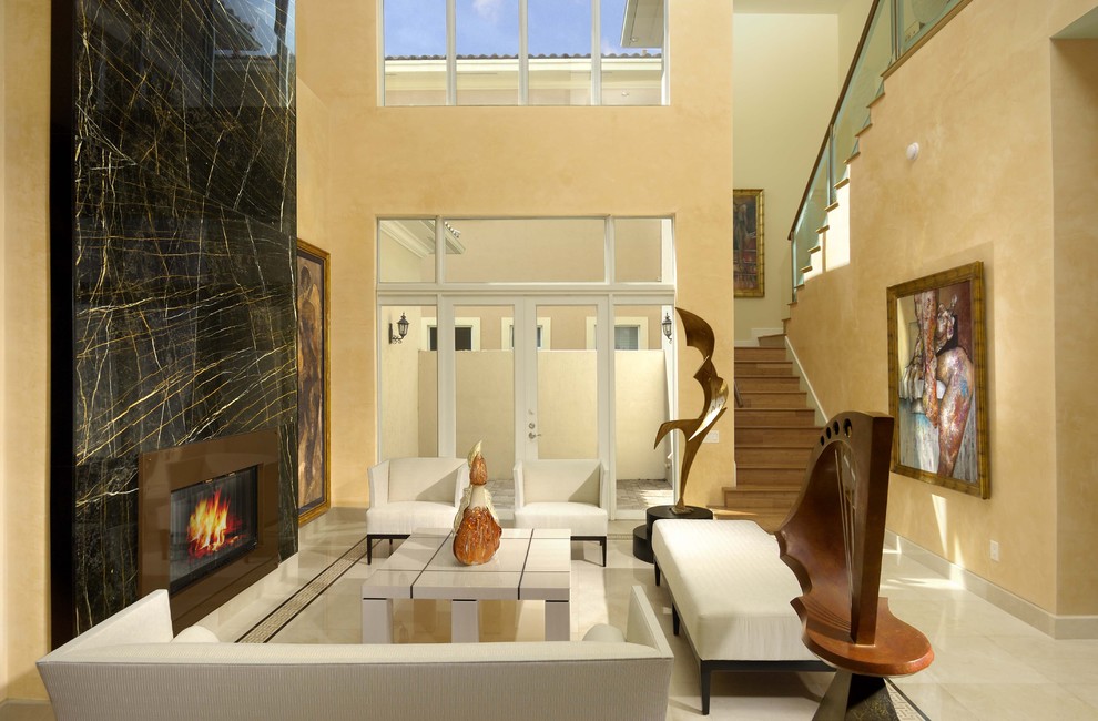 Großes, Repräsentatives, Fernseherloses, Abgetrenntes Modernes Wohnzimmer mit beiger Wandfarbe, Gaskamin, Kaminumrandung aus Stein und Steinwänden in Miami