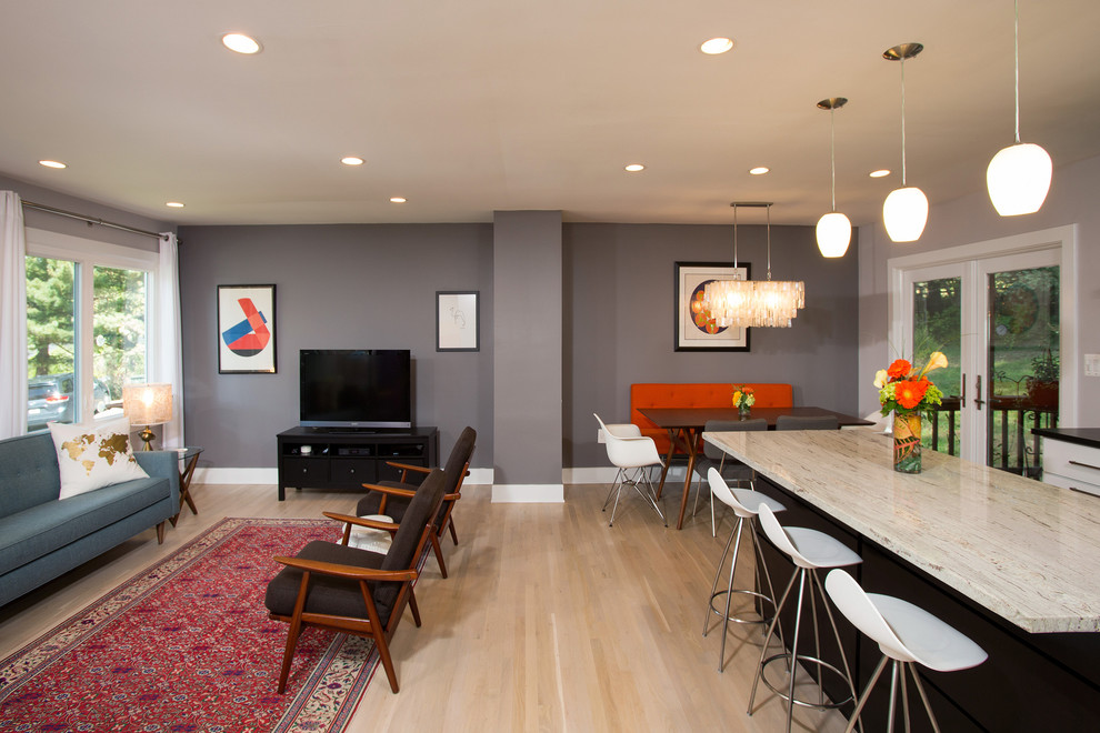 Foto de salón abierto contemporáneo con paredes grises, suelo de madera clara y televisor independiente