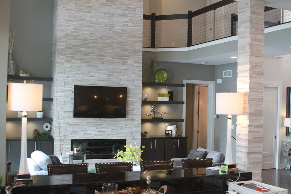 На фото: парадная, открытая гостиная комната среднего размера в современном стиле с серыми стенами, темным паркетным полом, горизонтальным камином, фасадом камина из камня, телевизором на стене и коричневым полом с