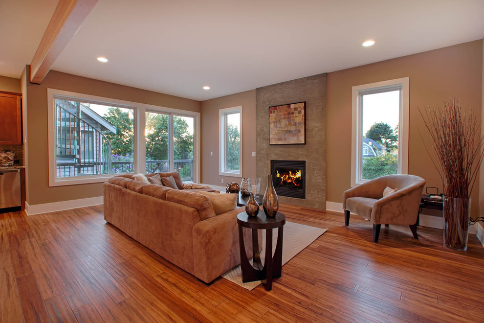 Example of a large trendy open concept and formal bamboo floor and brown floor living room design in Seattle with beige walls, a standard fireplace, a concrete fireplace and no tv