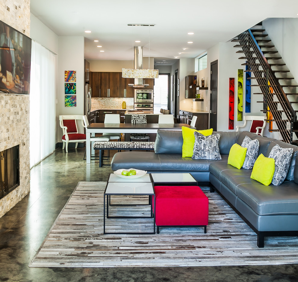 Kleines, Offenes Modernes Wohnzimmer mit grauer Wandfarbe, Betonboden, Kamin, Kaminumrandung aus Stein und TV-Wand in Austin
