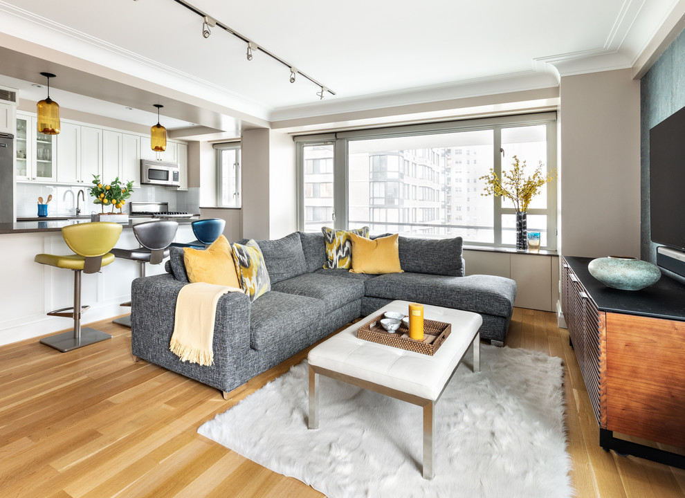 Mittelgroßes, Offenes Modernes Wohnzimmer ohne Kamin mit grauer Wandfarbe, hellem Holzboden, TV-Wand und beigem Boden in New York