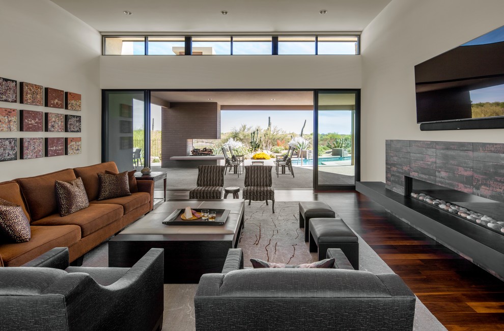 This is an example of a contemporary open plan living room in Santa Barbara with white walls, dark hardwood flooring, a ribbon fireplace, a wall mounted tv and brown floors.