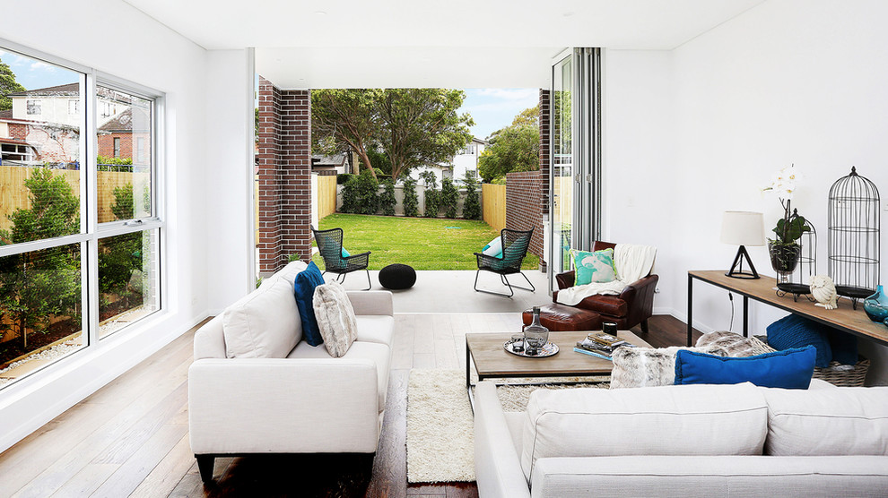 Offenes Modernes Wohnzimmer mit weißer Wandfarbe und braunem Holzboden in Sydney